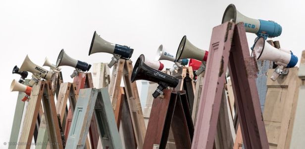 Kader Attia, Asesinos! Asesinos! installazione di 134 porte in legno, 47 megafoni, 2014.