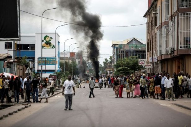 1089430-des-kinois-regardent-des-manifestants-bruler-des-pneus-au-cours-d-une-marche-anti-kabila-a-kinshasa-